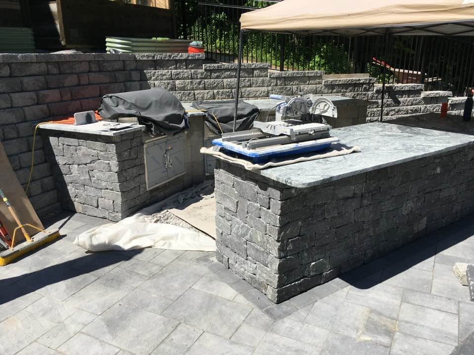 Outdoor kitchen under construction with stone surround